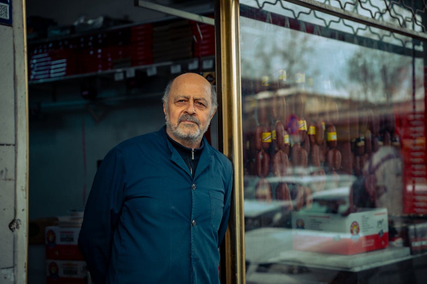 Local shop owner standing beside a storefront display